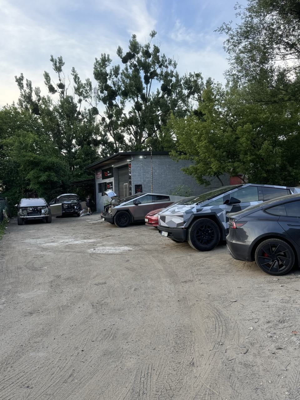 Парковка клієнтських Tesla біля сервісу вдень
